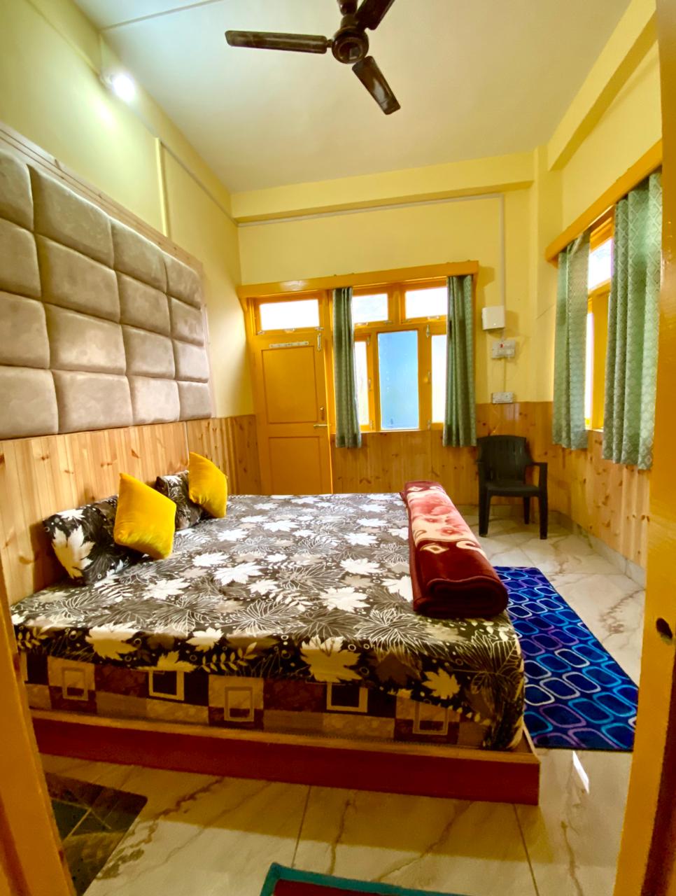 Standard Room with padded headboard and yellow cushions
